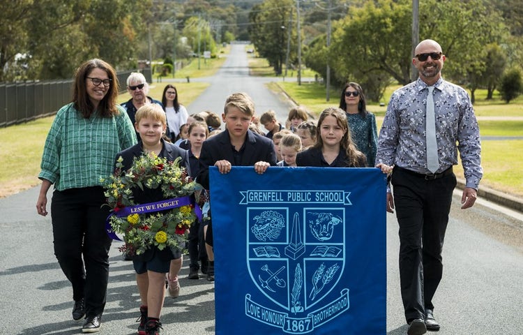 Students and teachers pay their respect during the ANZAC Day march.