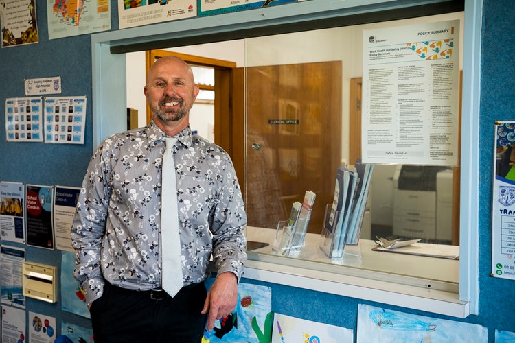 The principal smiling in the office.