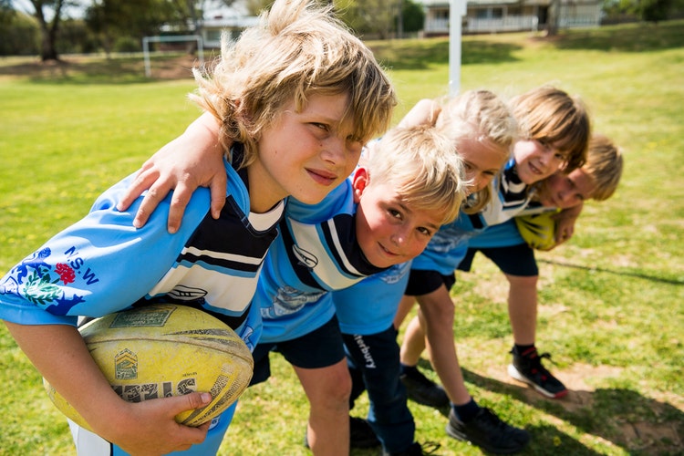 Boys in a huddle playing football.