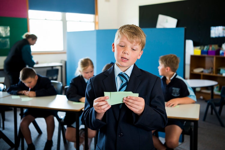 A student reads his notes while participating in a debate competition.