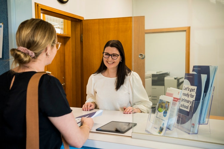 A parent is talking to the Office Manager.