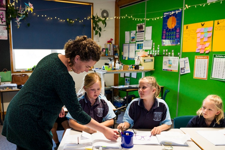 A teacher assisting students in the classroom.